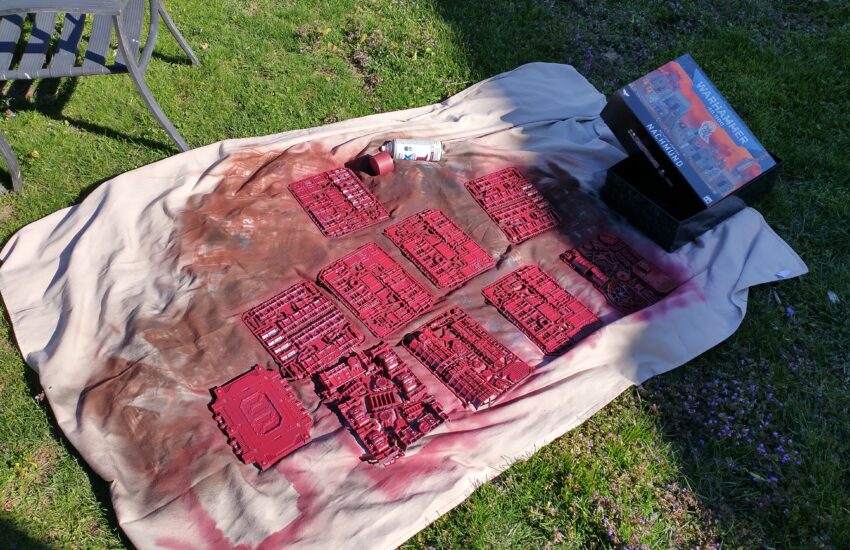 A set of primed wargaming terrain on a dropcloth, outside.