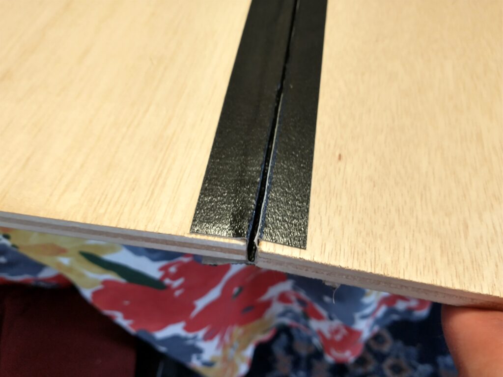 Two boards taped together, showing the hinge made of tape.