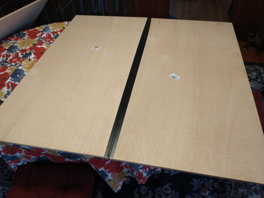 Two boards with a tape hinger laying flat.