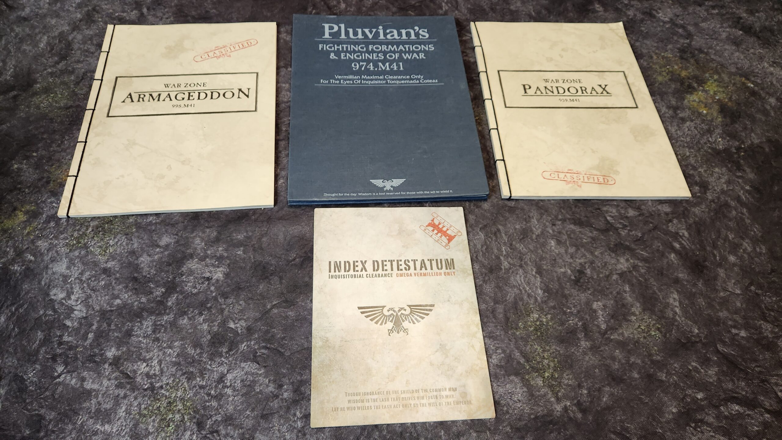 A set of four books from the Warhammer 40K universe.  Warzone Armegeddon, Warzone Pandorax, Indext Detestatum, and Pluvian's fighting Formations & Engines of War 974.M41